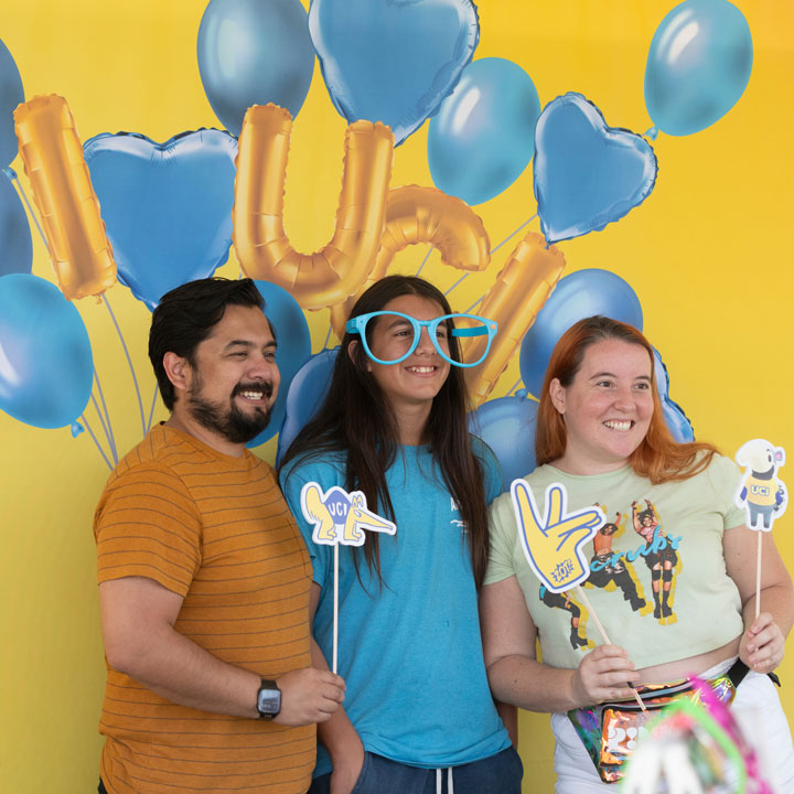 Community members take a photo at a UC Irvine sponsored photo booth at event