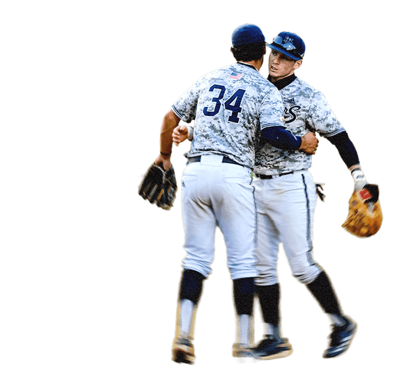 Two baseball players are chest-to-chest, reaching their right arms around each other.